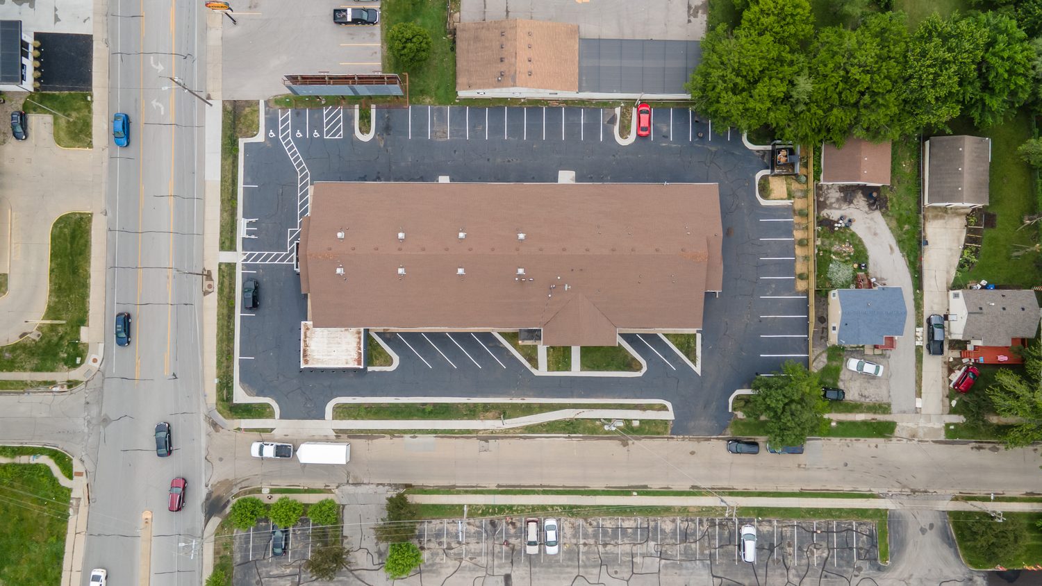 Aerial view of The View on Douglas showing the two-story building, the striped parking lot that wraps it, and the surrounding Des Moines neighborhood.