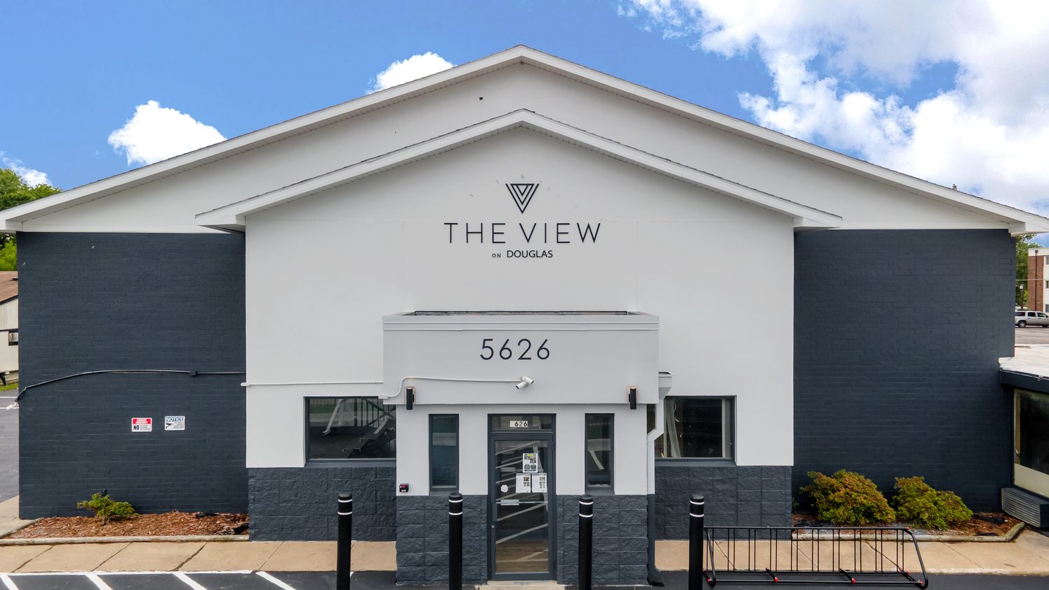 The main entrance of The View on Douglas under a white gable, with the property sign and the 5626 street number above the doors.